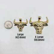 Size comparison of Large and X Large gold bull head pendants beside a quarter.
