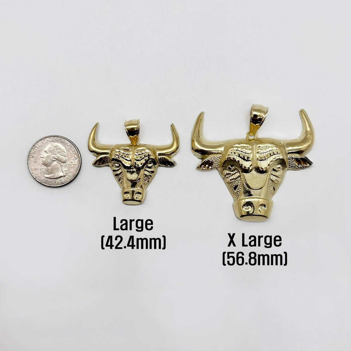 Size comparison of Large and X Large gold bull head pendants beside a quarter.