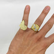 Hand wearing two gold rings one nugget style one textured designs 