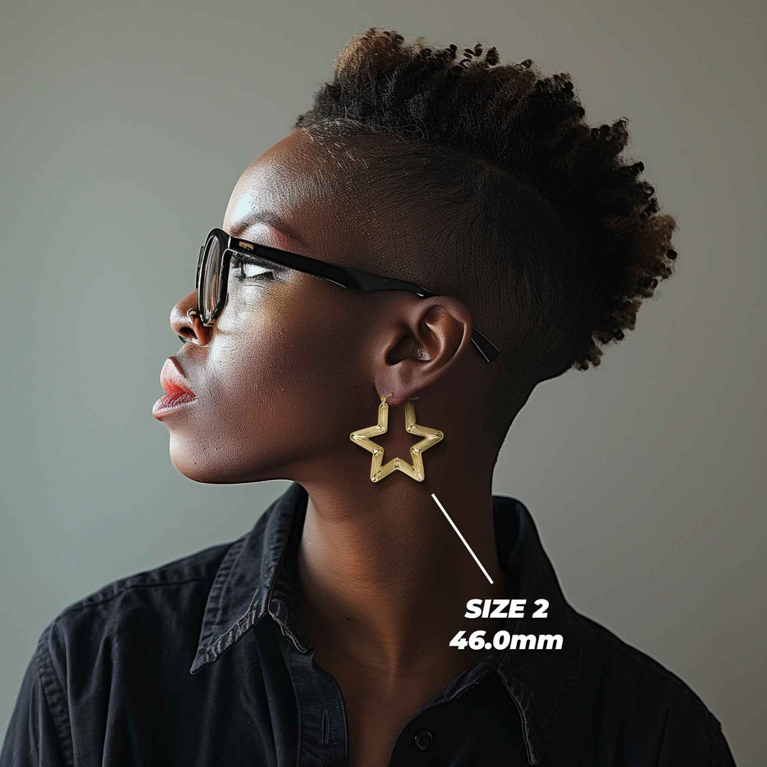 Profile view of a model wearing 46mm 10k gold star-shaped bamboo hoop earrings.