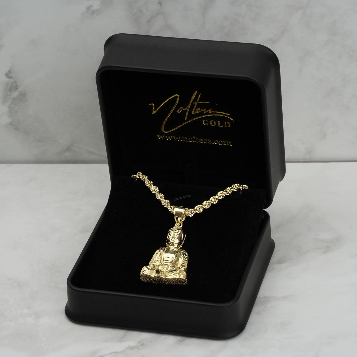 A 10k gold Buddha pendant and rope chain inside an open branded black jewelry box.