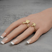 Overhead view of two yellow gold Egyptian queen Nefertiti rings modeled on a hand.