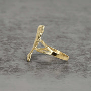 Side view of 10k gold classic Nefertiti ring showing profile details on gray surface.