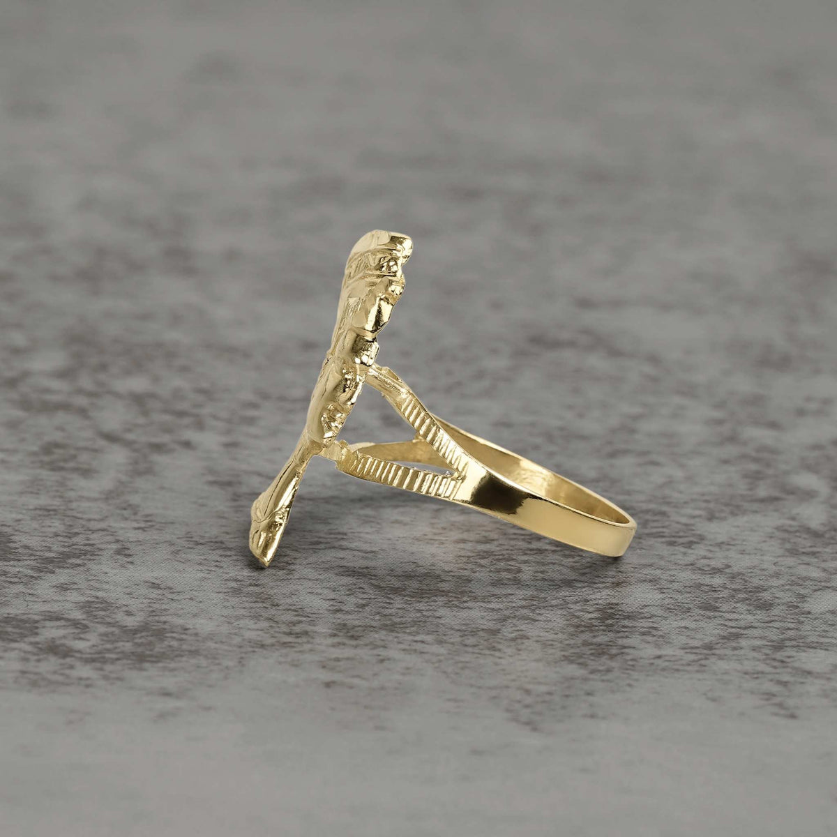 Side view of 10k gold classic Nefertiti ring showing profile details on gray surface.