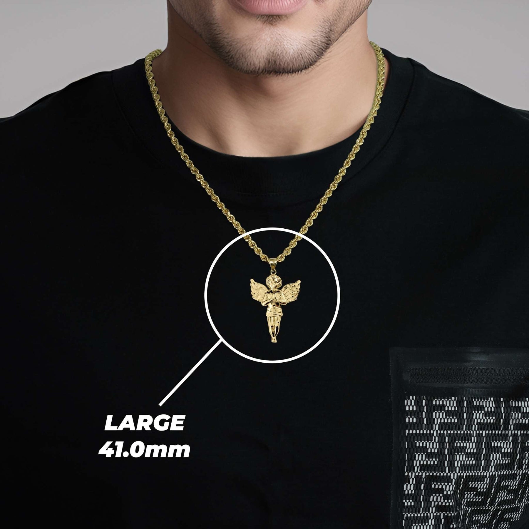 A man wearing a large gold angel pendant labeled LARGE 41.0mm.