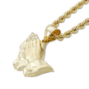 Polished yellow gold praying hands pendant paired with a matching rope chain on white.