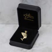 Gold Nefertiti pendant displayed in an open black jewelry box on a marble surface.