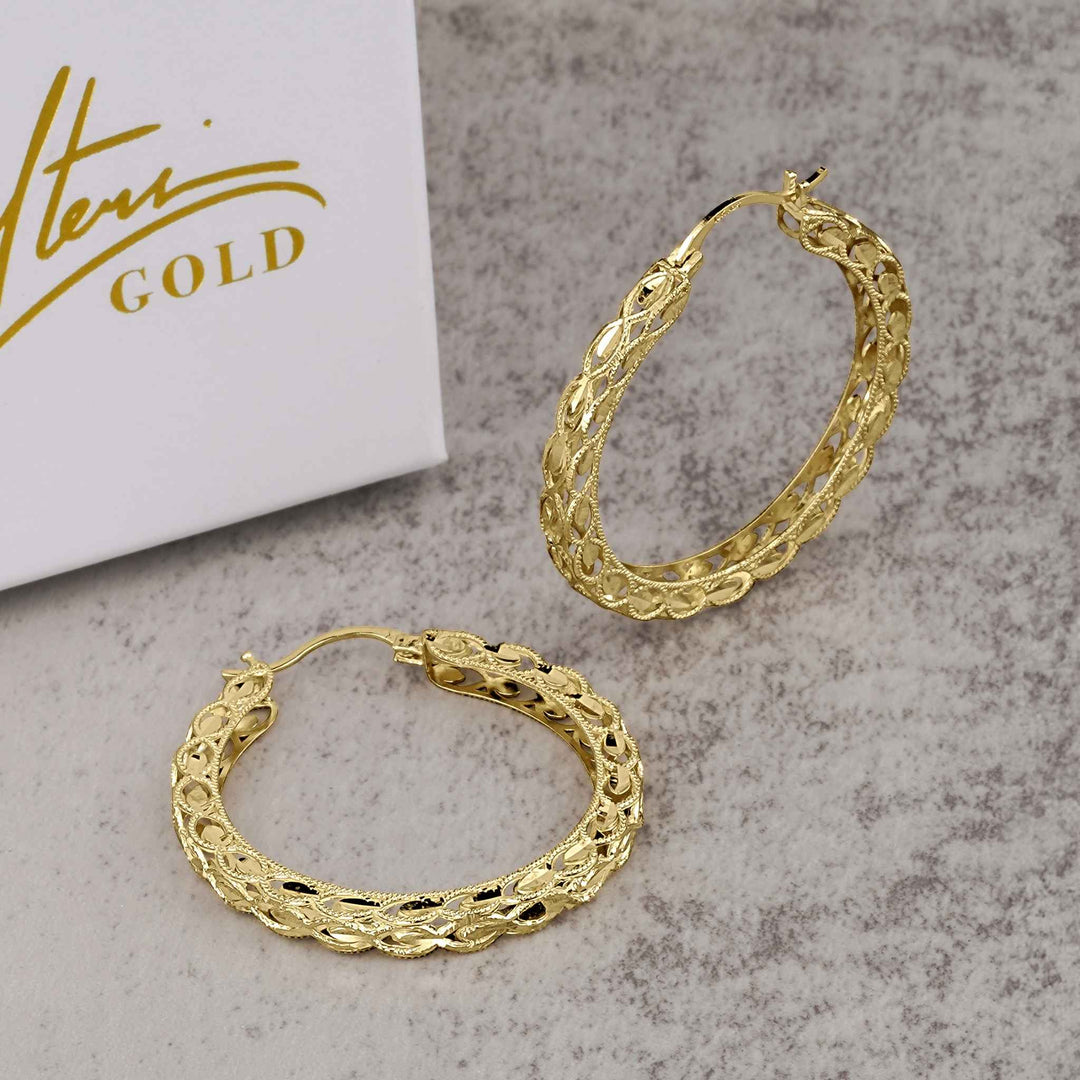 A pair of 10k gold round Turkish hoop earrings featuring an intricate textured pattern.