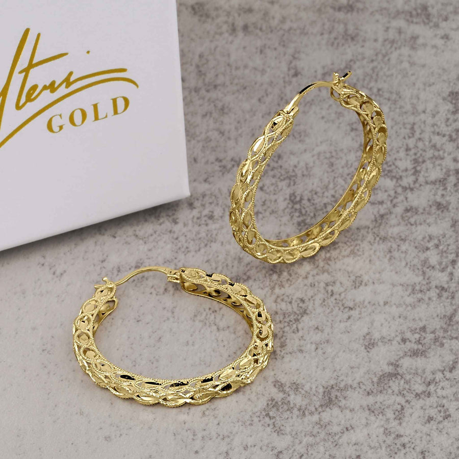 A pair of 10k gold round Turkish hoop earrings featuring an intricate textured pattern.
