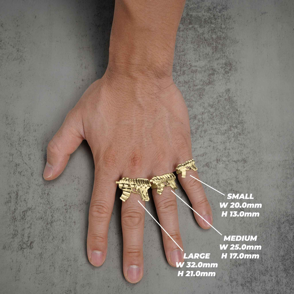 Model wearing three different sizes of gold Uzi weapon rings with dimensions on gray.