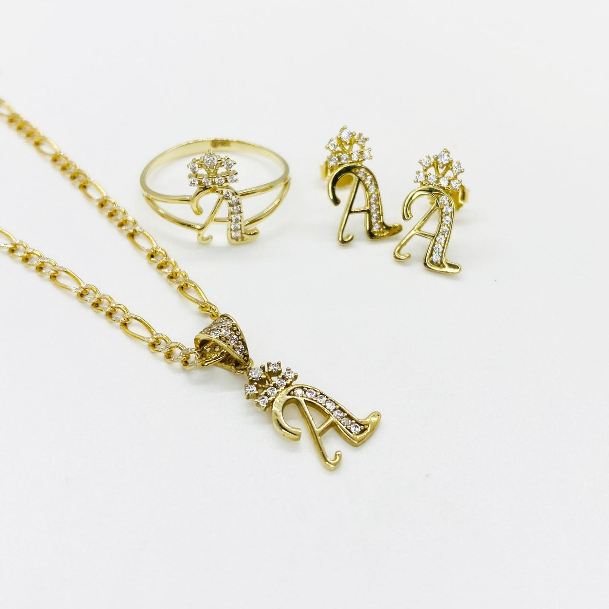 10k gold A initial collection including cursive stud earrings, matching ring, and gold pendant.