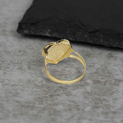 Side-back profile of a yellow gold ring revealing the open-back pavé heart setting.