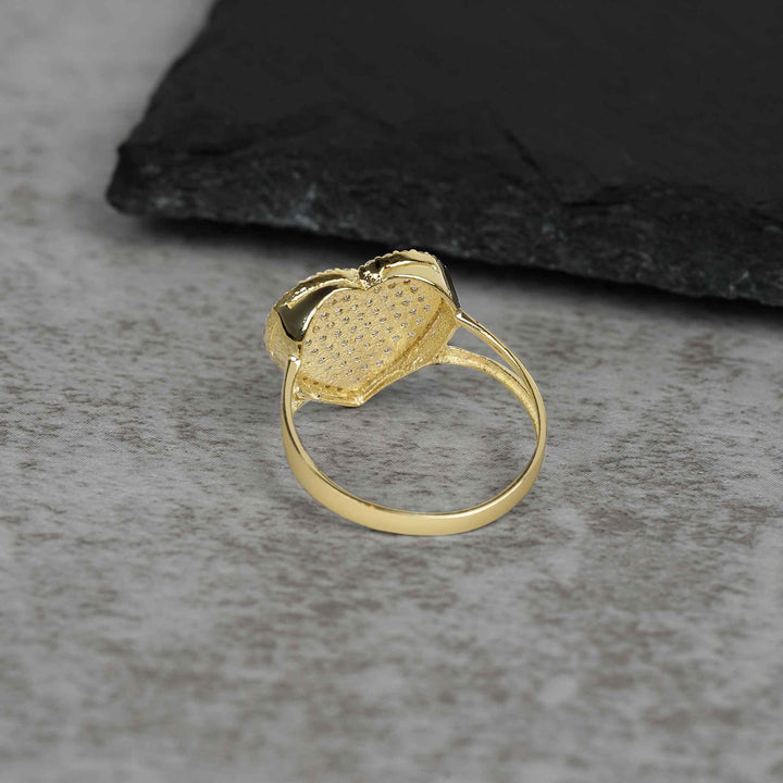 Side-back profile of a yellow gold ring revealing the open-back pavé heart setting.
