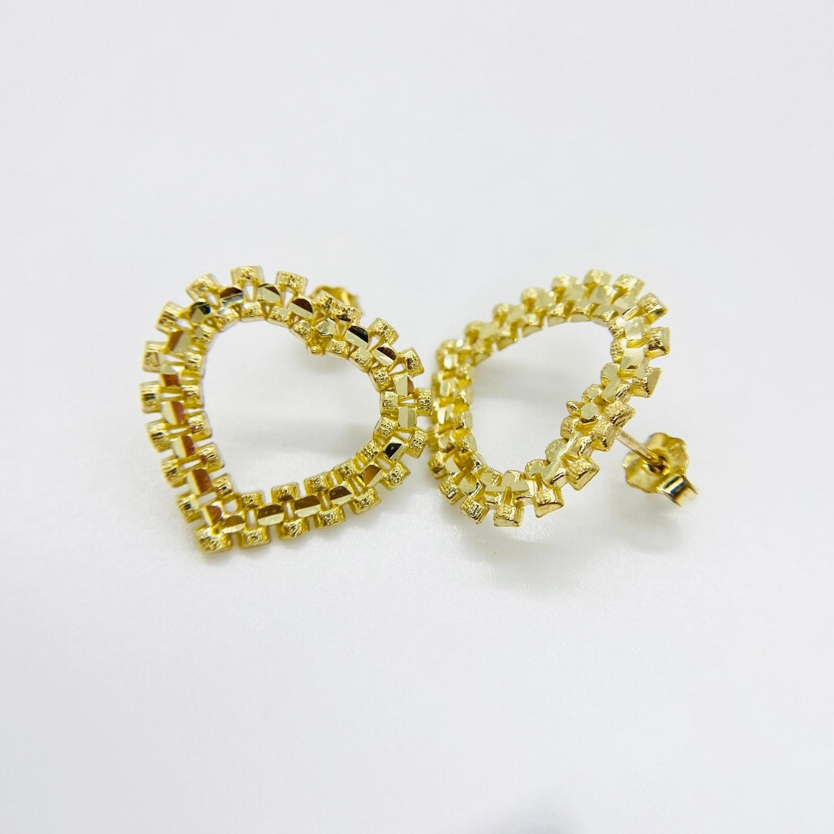 Pair of 10k yellow gold diamond-cut rollie style heart stud earrings.