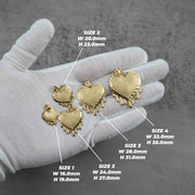 A white-gloved hand displays four gold heart-shaped pendants with size labels and dimension measurements.