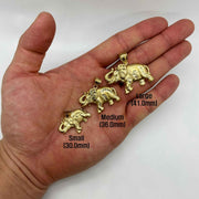 Small, Medium, and Large 10k gold elephant pendants displayed in an open palm with size labels.