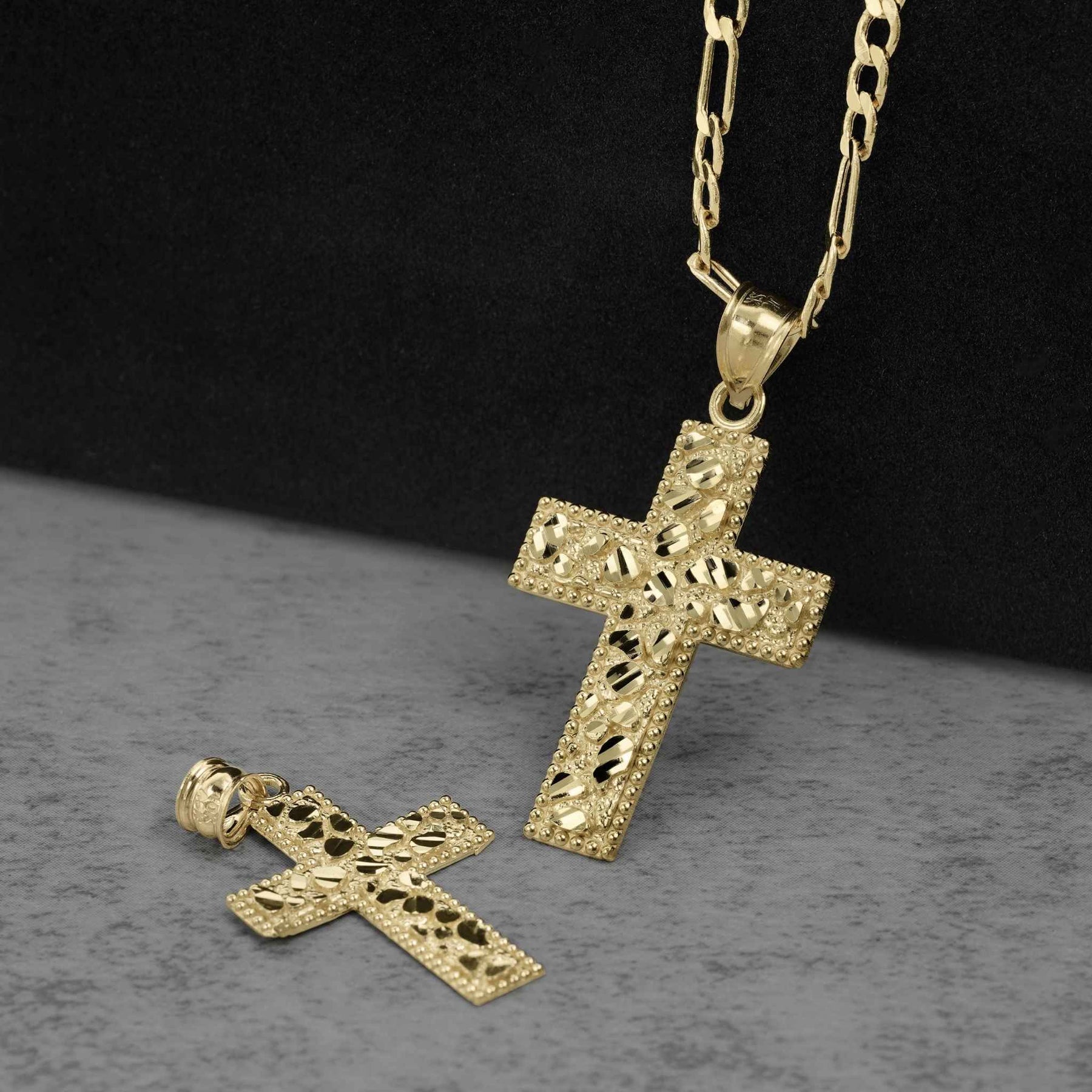 Gold cross pendant with diamond-cut nugget texture displayed on a dark background.