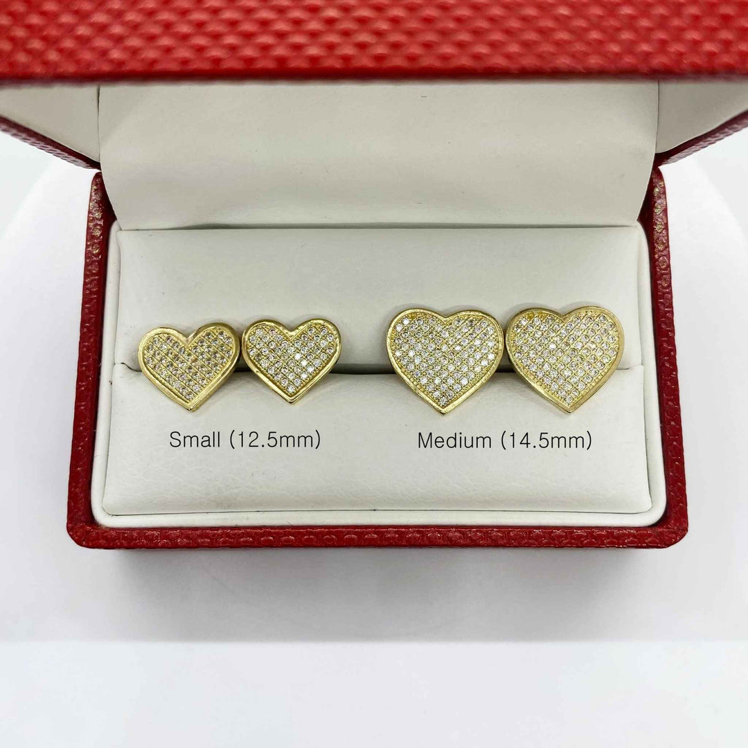 Size comparison of small 12.5mm and medium 14.5mm 10k gold heart-shaped CZ stud earrings.