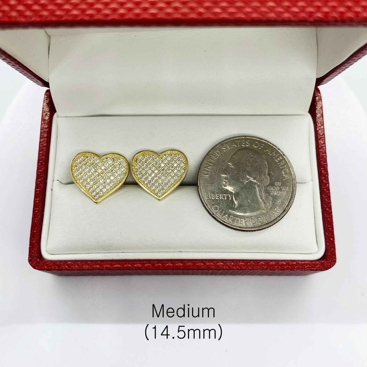 Medium 14.5mm heart-shaped 10k gold CZ stud earrings next to a US quarter.