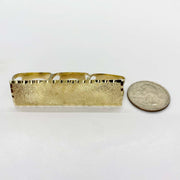 10k Gold Classic Flat Three Finger ring  next to a coin for scale on a white background