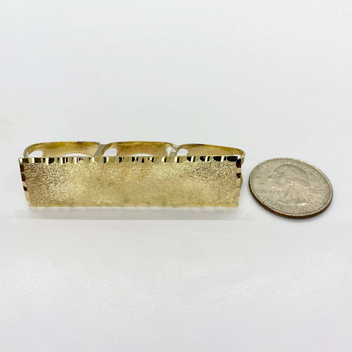 10k Gold Classic Flat Three Finger ring  next to a coin for scale on a white background
