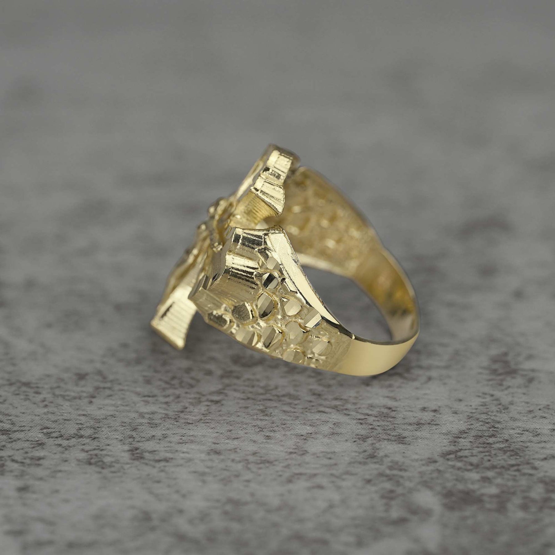 10k gold gothic cross nugget ring side view on a gray background