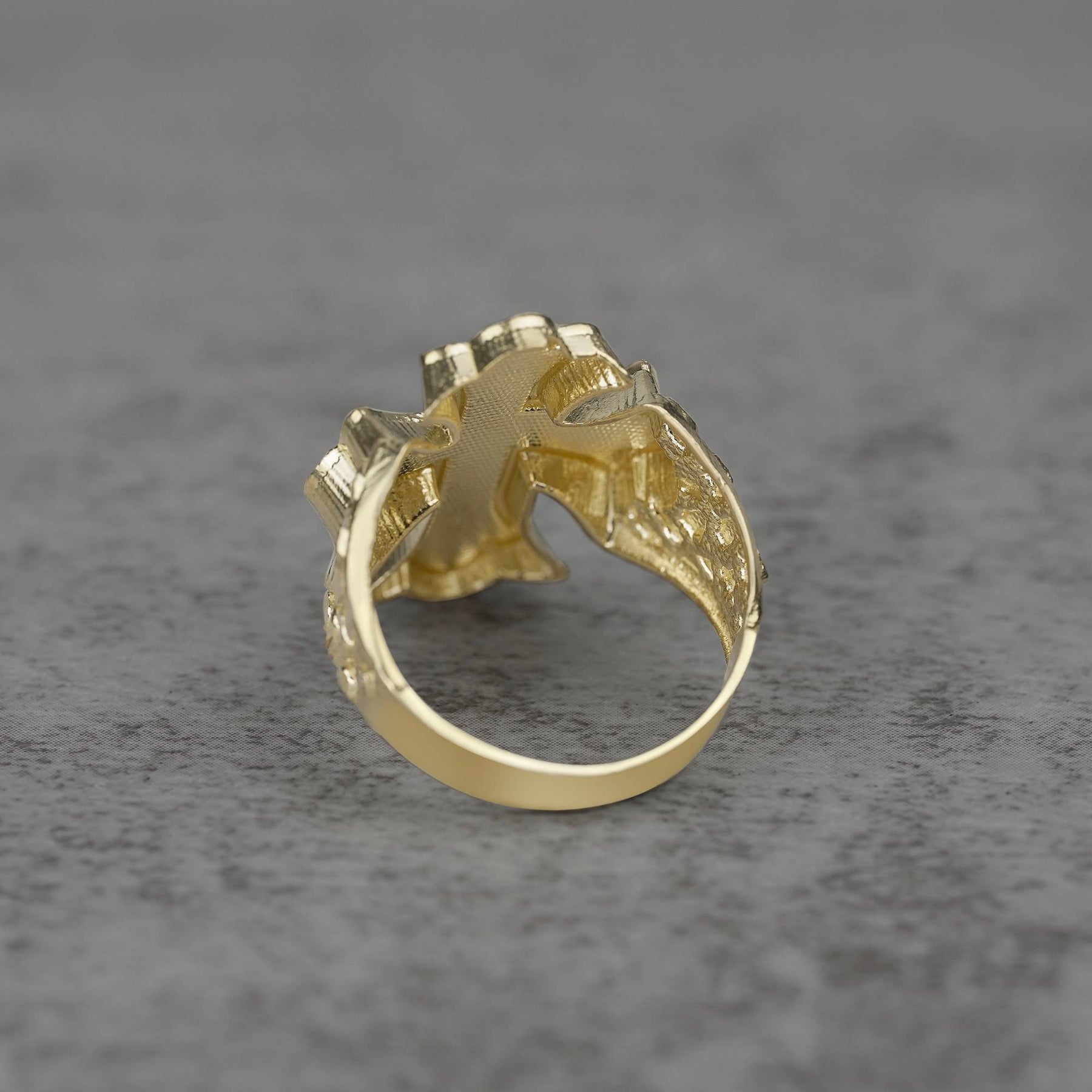 10k gold gothic cross nugget ring back view on a gray background