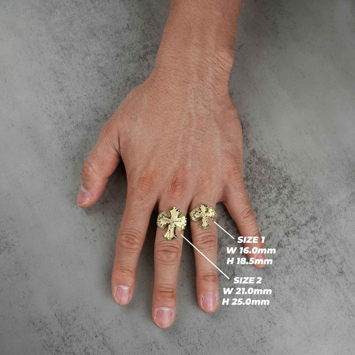 Gold crucifix ring worn on hand with dimension labels overlay on gray background.