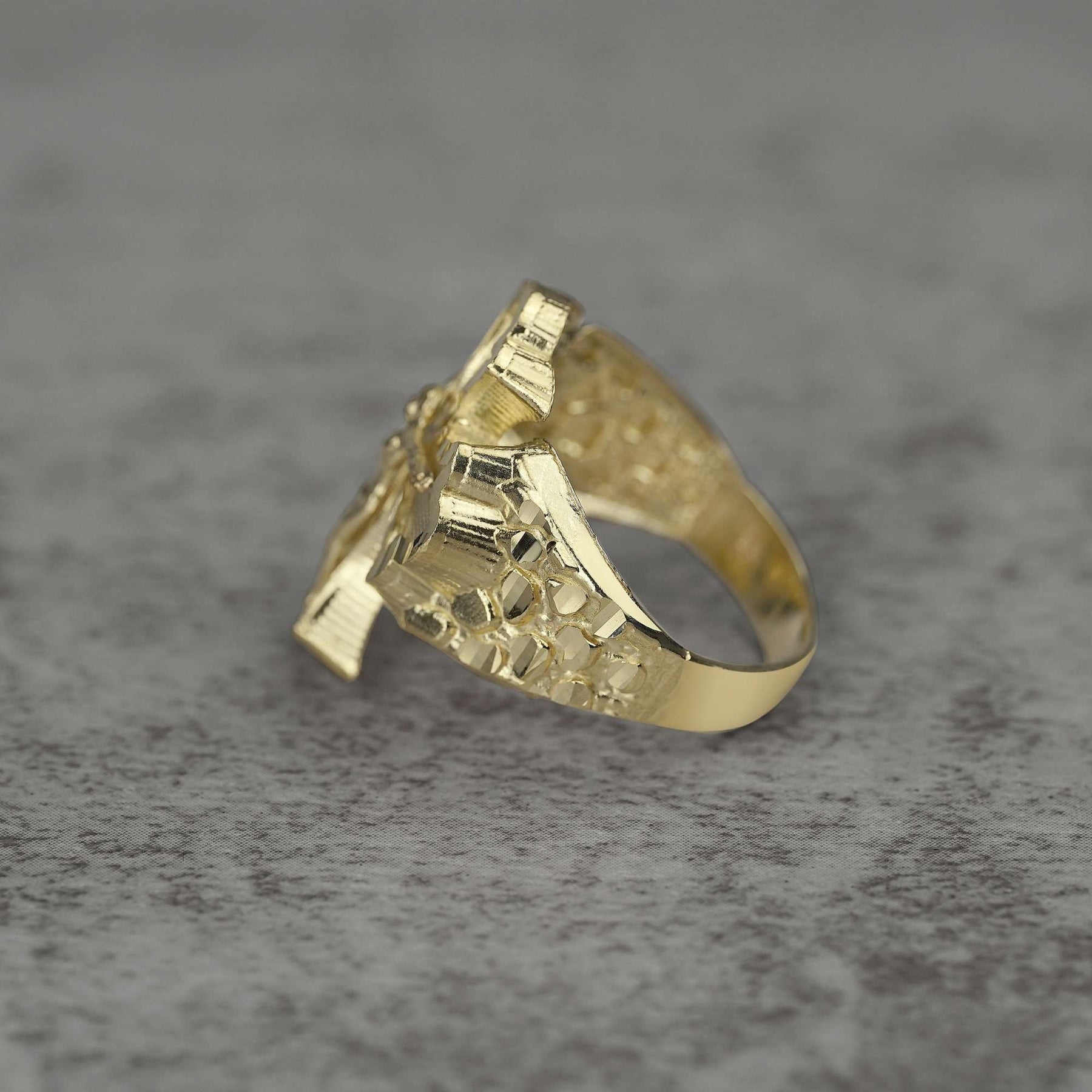 10k Gold ring with Gothic Crucifix design side view on a gray surface