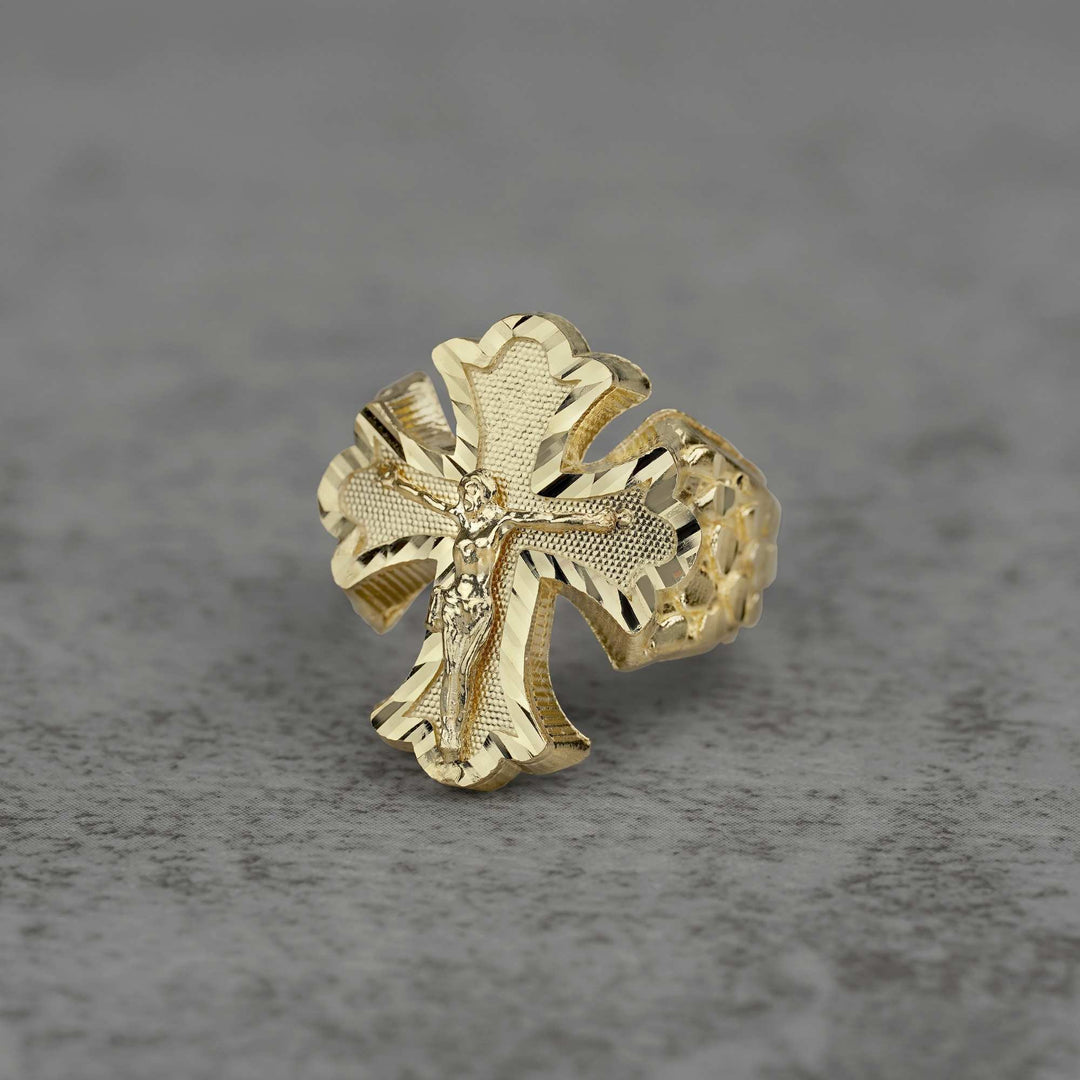 10k gold gothic crucifix nugget Ring on a gray textured background