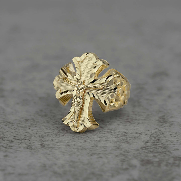10k gold gothic crucifix nugget Ring on a gray textured background