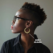 Model wearing Size 1 50.0mm 10k gold heart hoop earrings for size reference.