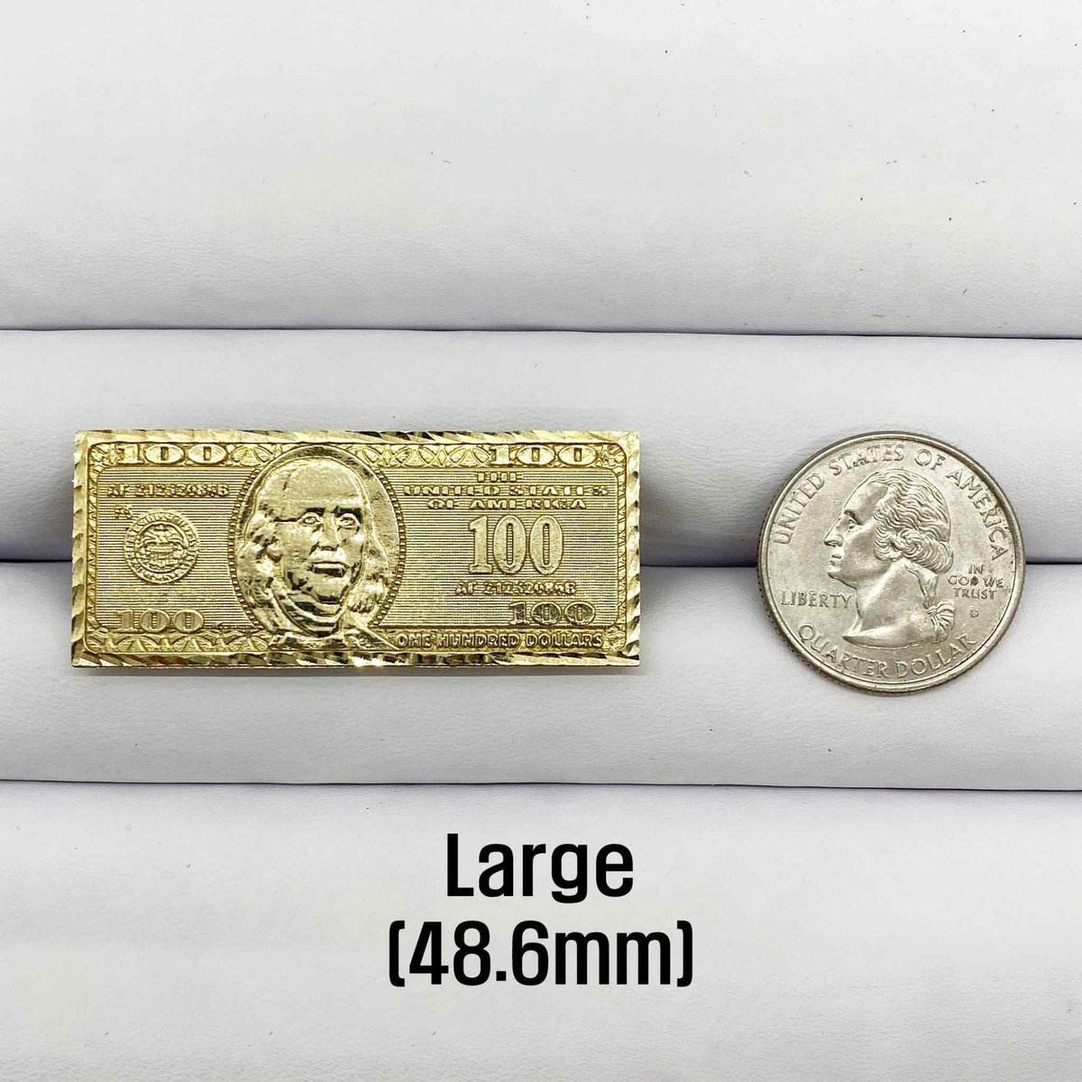 10k Gold ring with a hunderd dollar bill design next to a silver coin.
