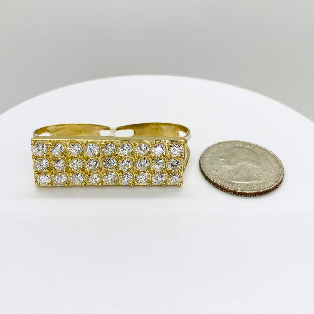 10k Gold two finger ring with rectangular design next to a quarter on a white surface