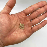 10k yellow gold initial letter A Rollie heart pendant resting on an open palm