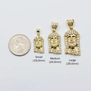 Small, medium, and large 10k gold Jesus pendants compared with a US quarter.