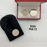 Pink CZ stud earring on an ear model next to a boxed earring and quarter.