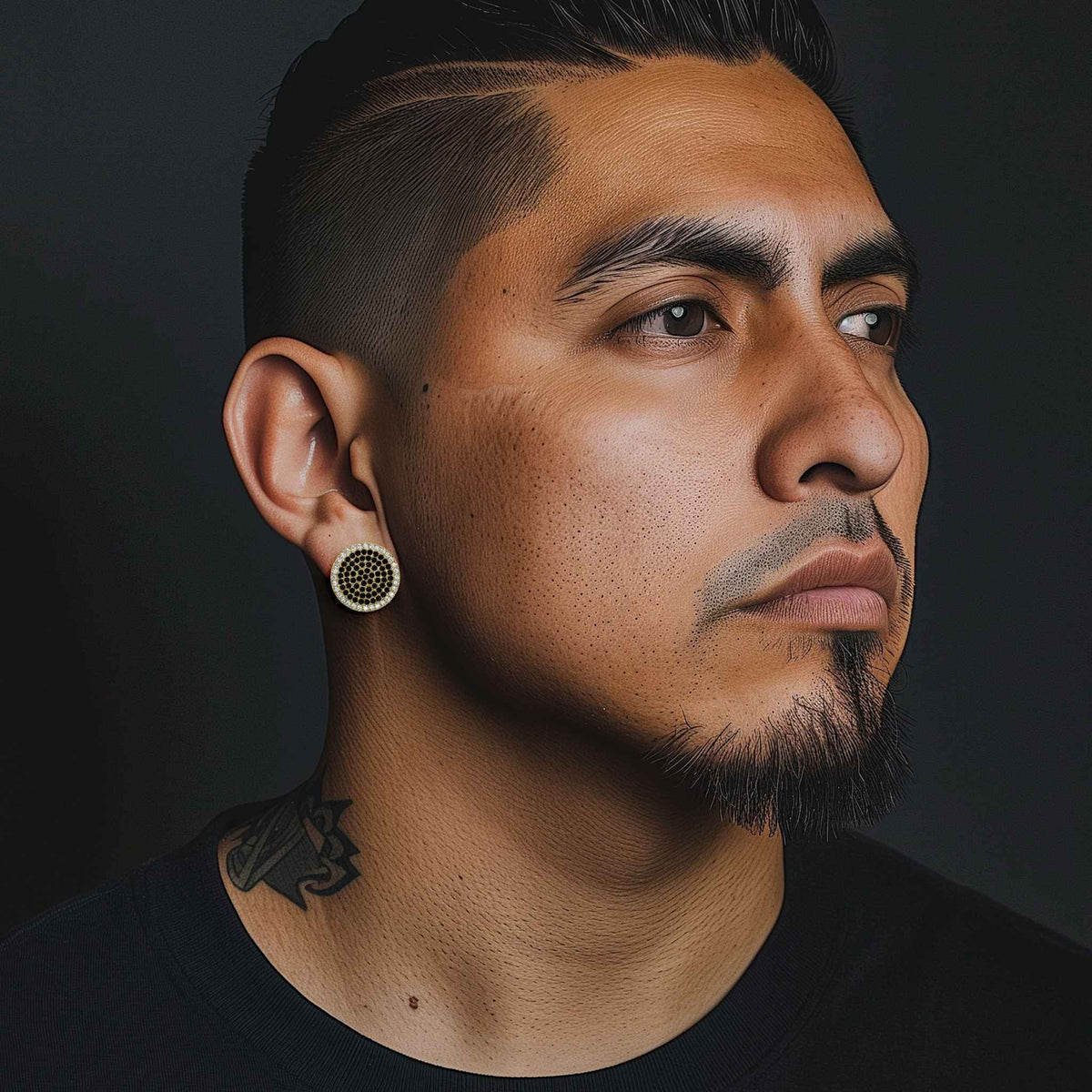 Man wearing 10k yellow gold jumbo round stud earrings with black cubic zirconia.