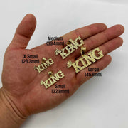 Four sizes of 10k gold King crown pendants displayed resting in an open hand.