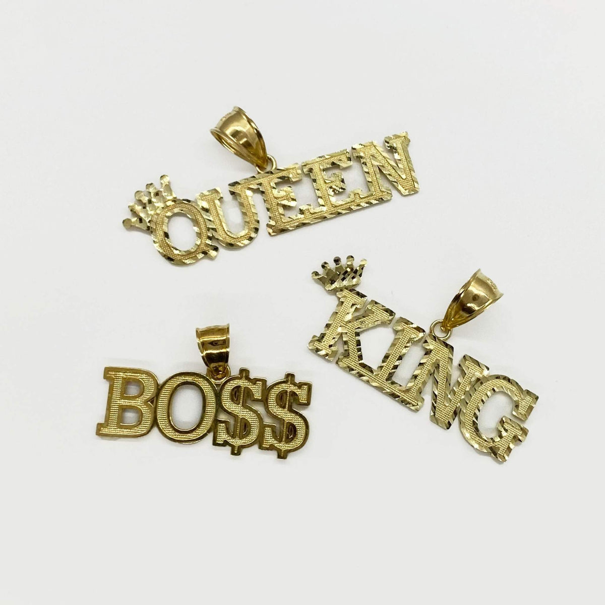 Selection of 10k yellow gold diamond-cut word pendants including Queen, King, and Boss.