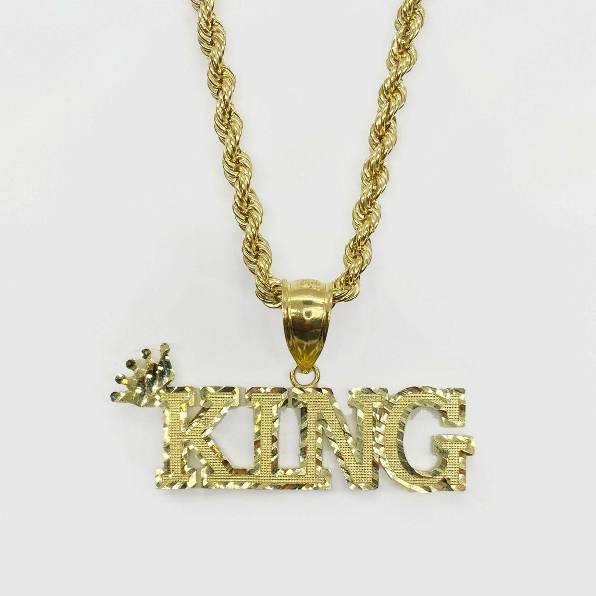 10k gold King crown word charm pendant with diamond-cut texture on a rope chain.