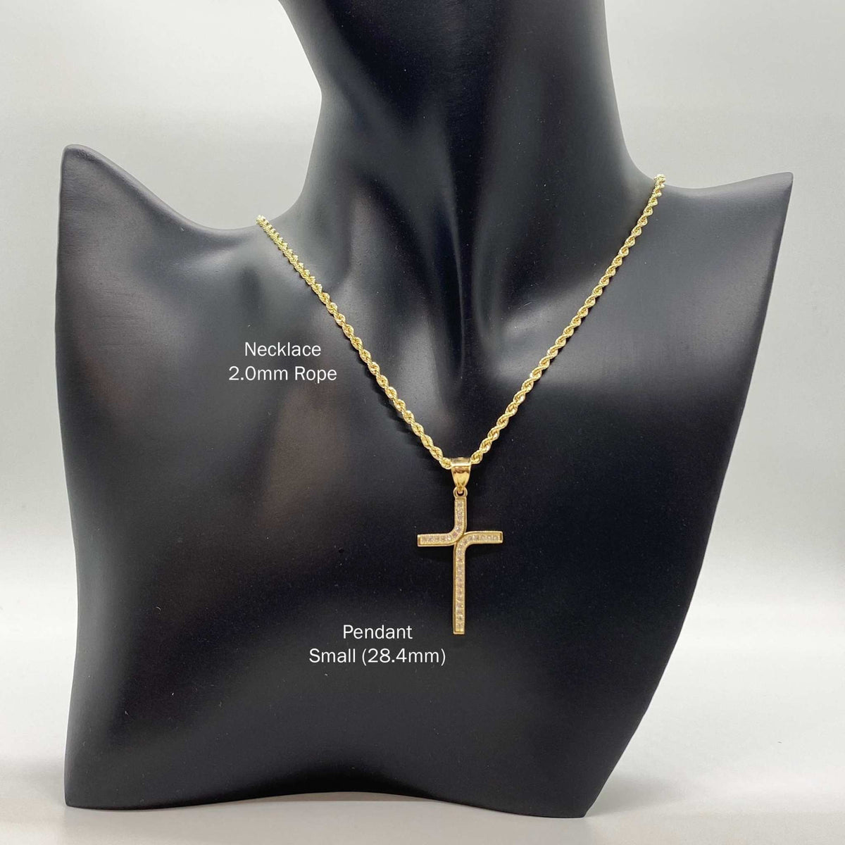 Small 28.4mm 10k gold iced-out L-cross CZ pendant on a 2.0mm rope chain on a mannequin.