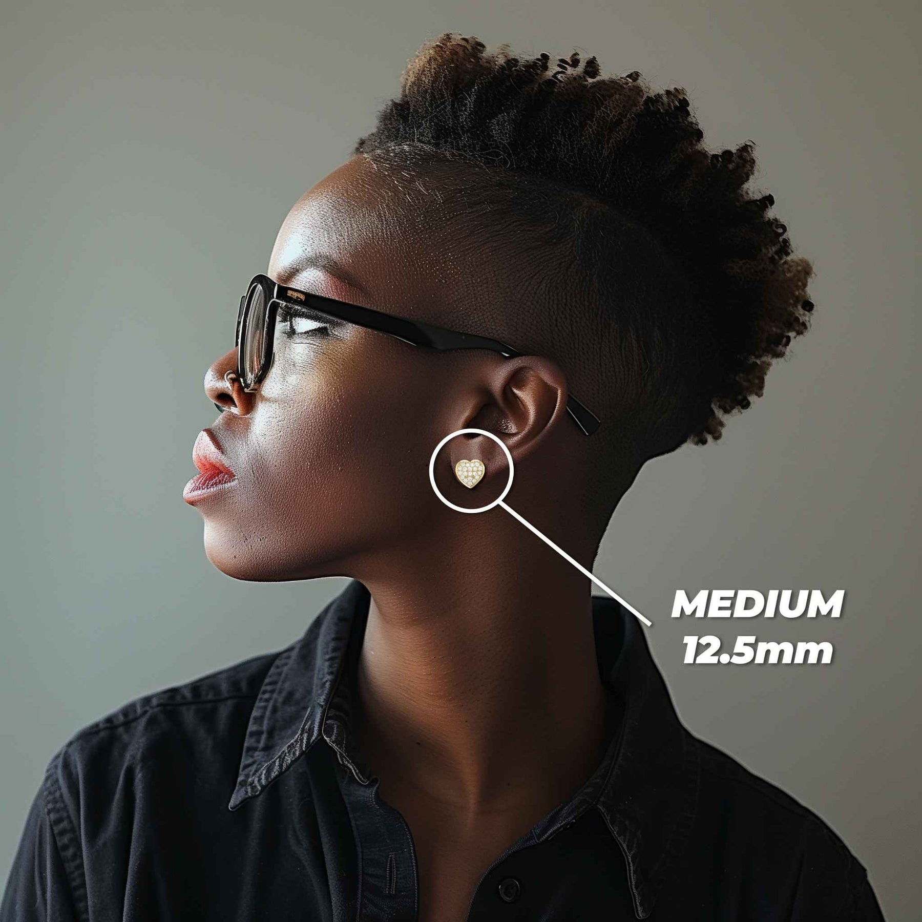 Woman wearing Medium 12.5mm 10k gold heart cubic zirconia stud earrings for scale.