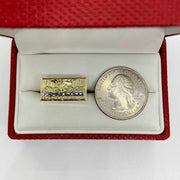 10k Gold ring with Last Supper design next to a silver dollar coin.