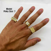 Hand wearing three gold rings with a plain background