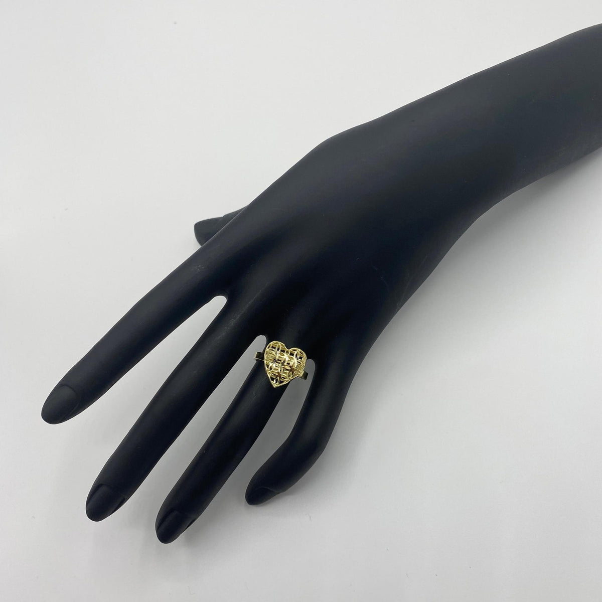10k Gold ring with mesh heart shape design on a black mannequin hand 