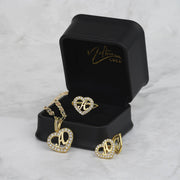 Gold heart-shaped jewelry set including a necklace pendant, ring, and earrings with letter 'A'.