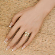 Close-up lifestyle view of a women's personalized gold cursive script letter ring on a finger.