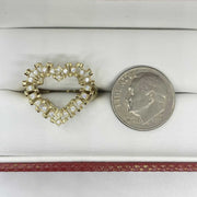 10k Gold heart shaped ring next to a quarter for scale on a white surface