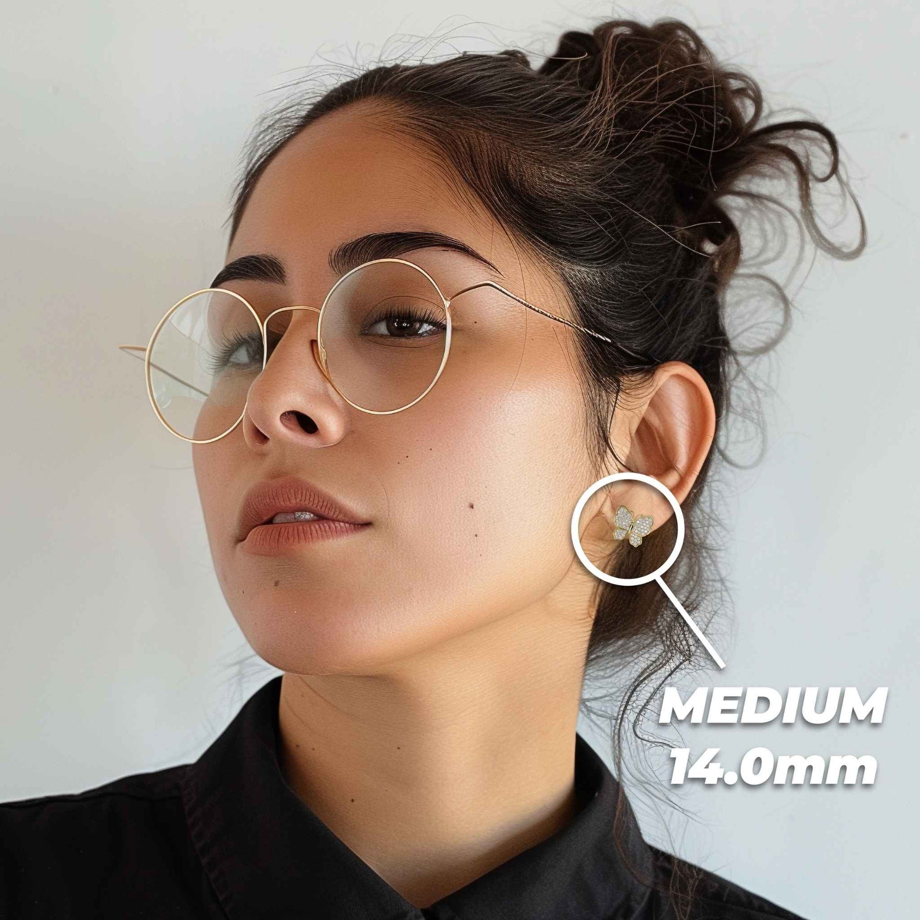 Model wearing medium 14.0mm gold butterfly stud earrings with cubic zirconia pavé.